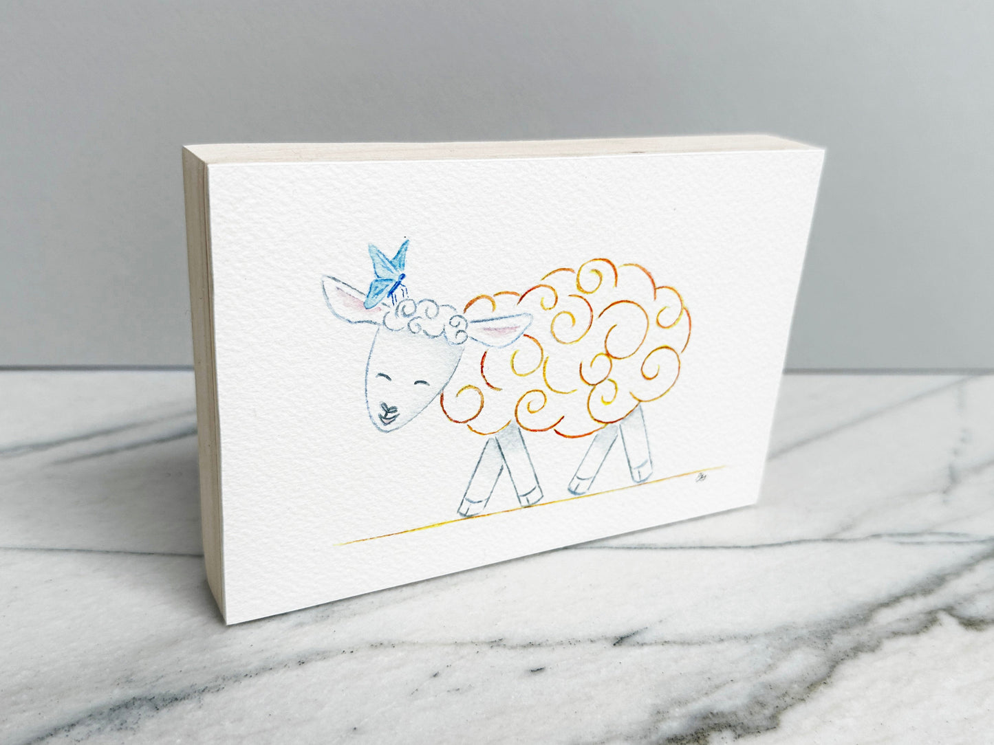 Clementine the Sheep, an original watercolor painting of a sheep with orange and gold curls and a blue butterfly, mounted on a cradled wood panel, side view