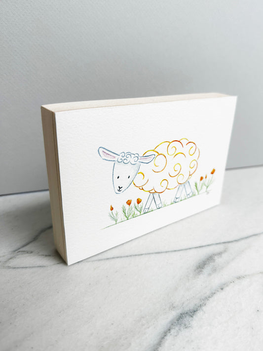 Poppy the Sheep, an original watercolor painting of a sheep with golden yellow curls among orange poppies, mounted on a cradled wood panel, side view