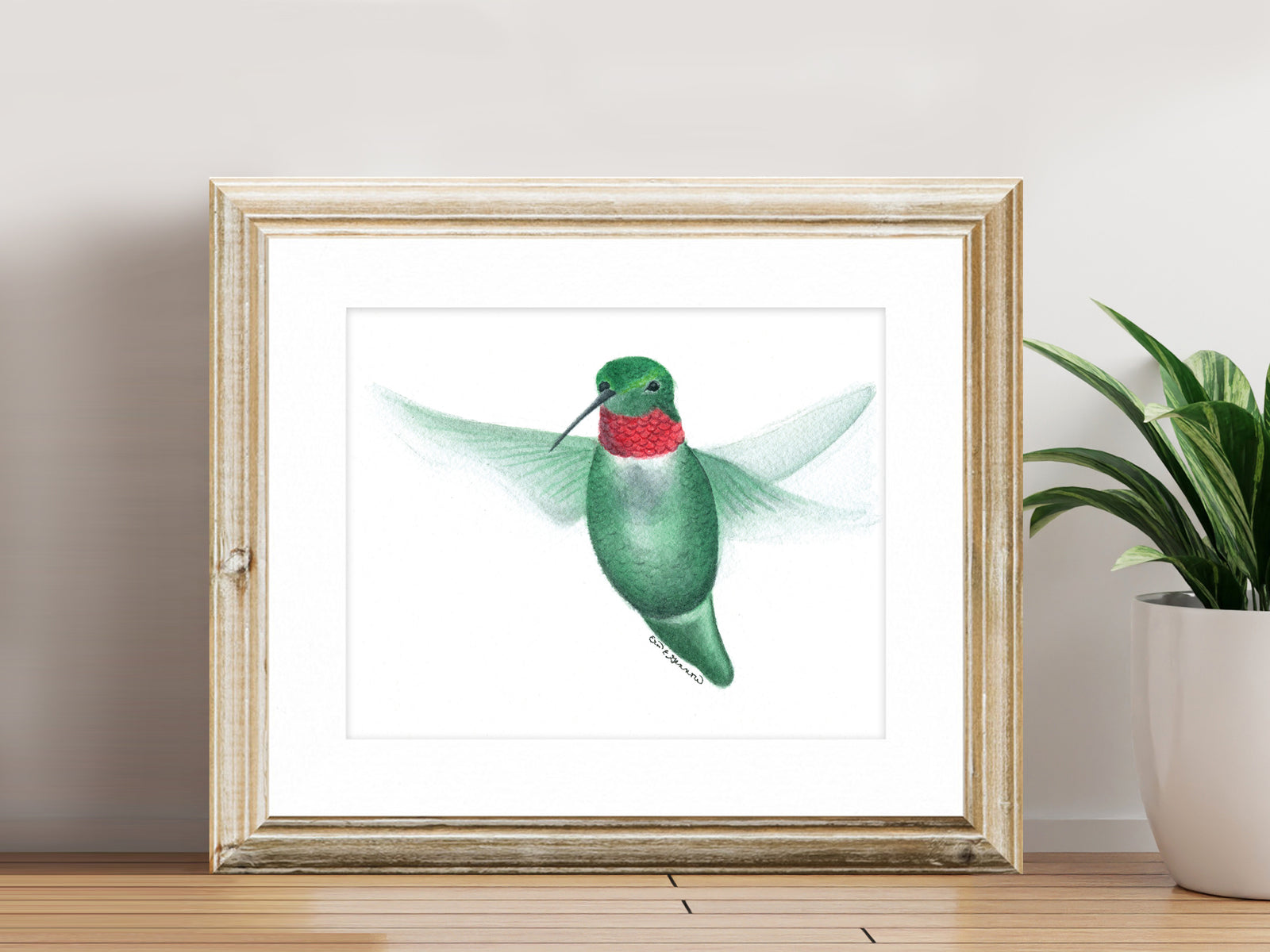 Framed watercolor hummingbird fine art print on a shelf